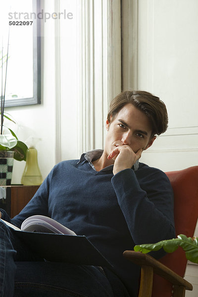 Mann sitzend mit Buch auf Schoß  Portrait