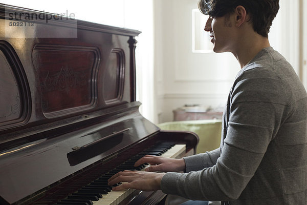 Junger Mann spielt Klavier