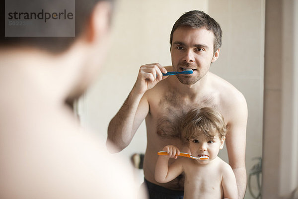 Vater und Kleinkind beim gemeinsamen Zähneputzen