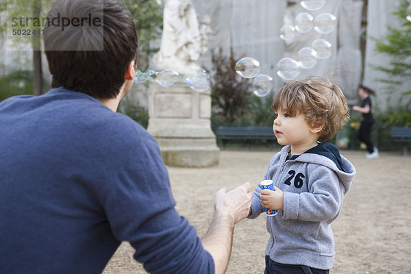 Vater und Kleinkind spielen mit Blasen