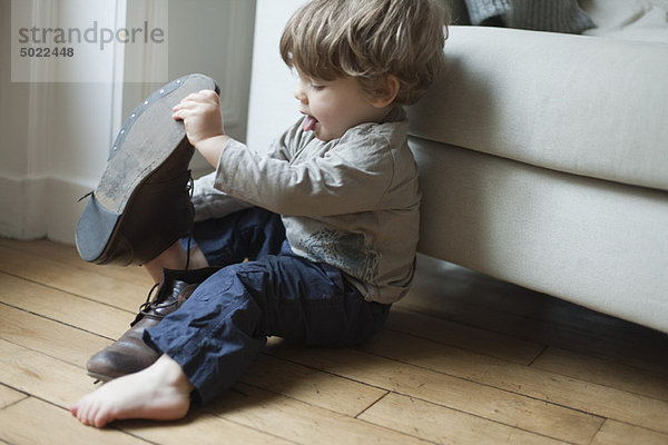 Kleinkind Junge spielt mit den Schuhen der Eltern