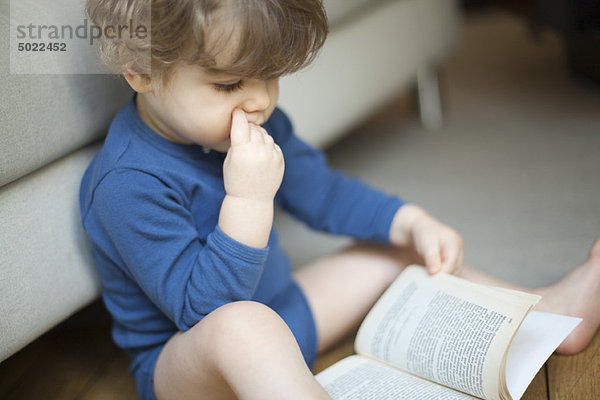 Kleinkind Junge schaut auf Buch