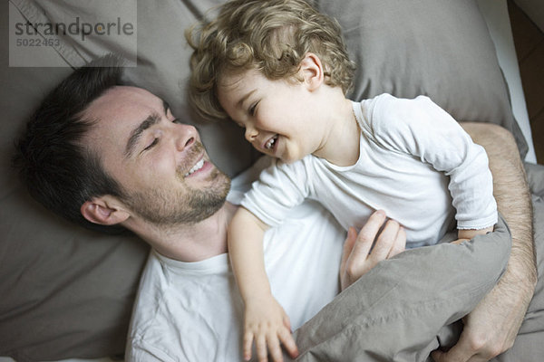 Vater und Sohn entspannen gemeinsam im Bett  Porträt