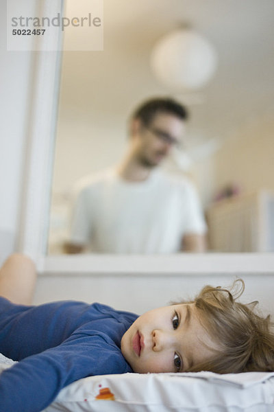 Baby auf dem Rücken liegend  Spiegelung des Vaters  der das Baby liebevoll im Spiegel betrachtet.