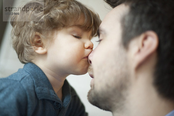 Kleinkind Junge küsst Vaters Nase