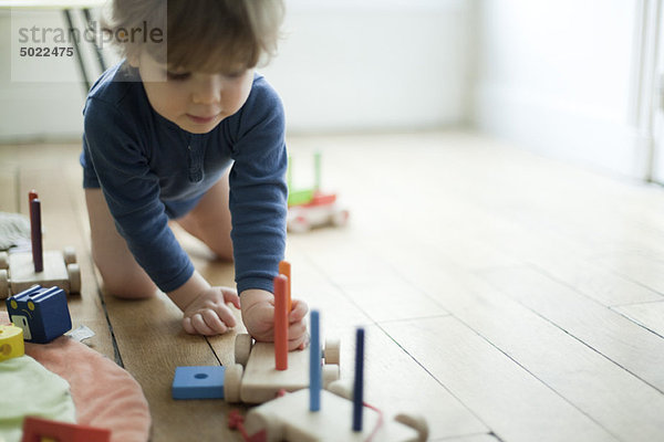Kleinkind Junge spielt mit Spielzeugeisenbahn