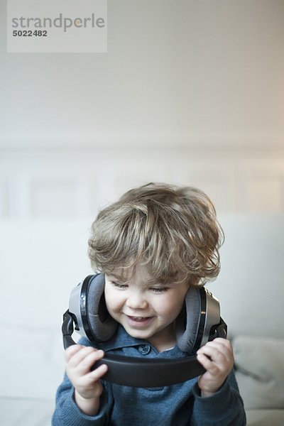 Kleinkind Junge spielt mit Kopfhörer  Portrait
