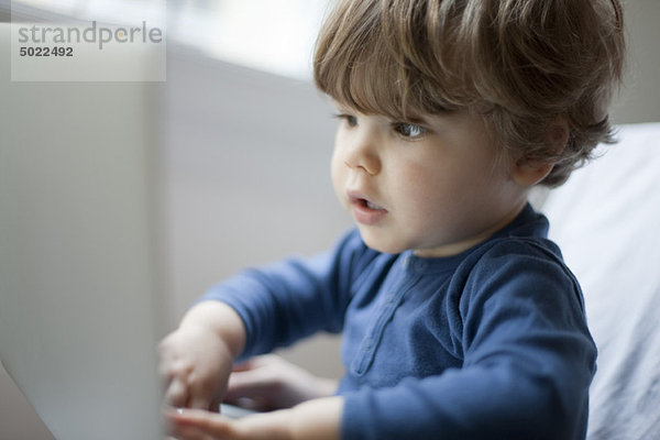 Kleinkind Junge spielt mit Laptop  Portrait