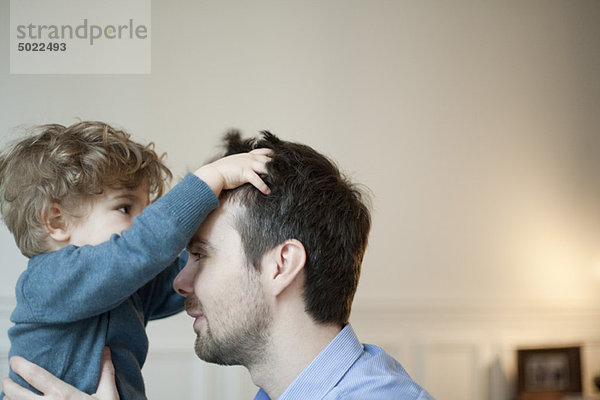 Kleinkind Junge spielt mit Vaters Haaren