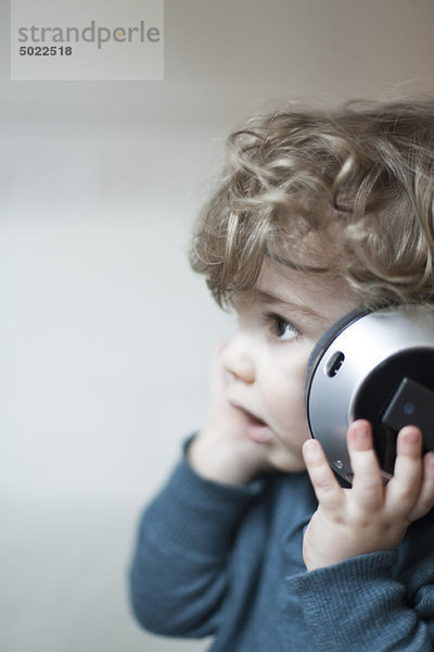 Kleinkind Junge hört Musik mit Kopfhörer  Portrait