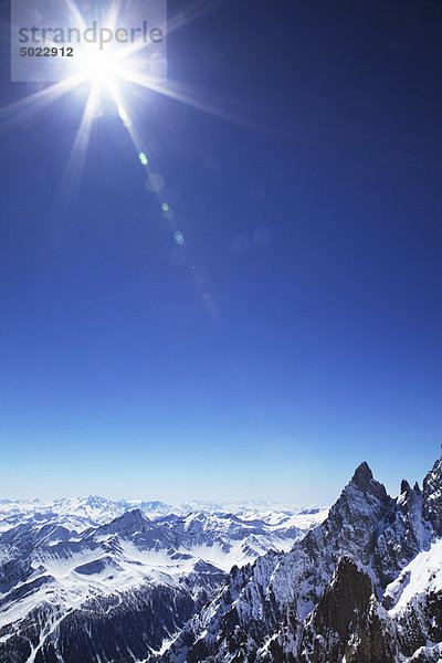 Sonne über schneebedeckten Bergen