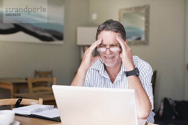 Frustrierter Geschäftsmann mit Laptop