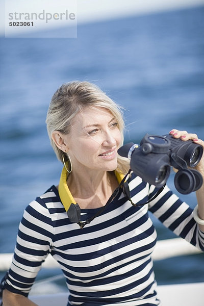 Frau mit Fernglas auf dem Boot