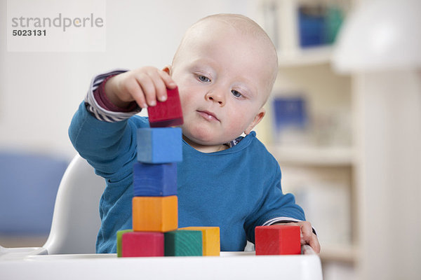 Junge spielt mit Spielzeugblöcken