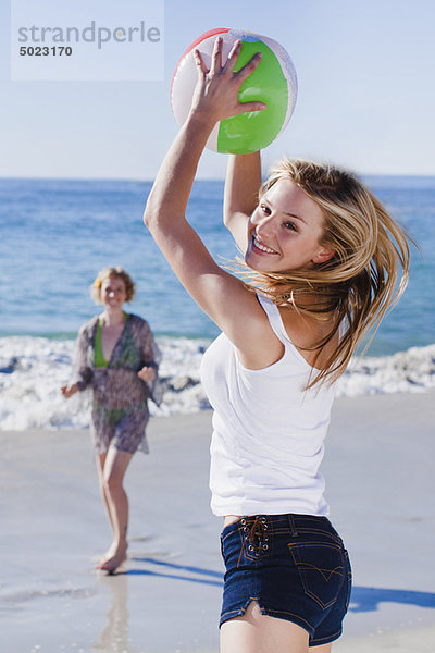 Frauen spielen mit dem Ball am Strand