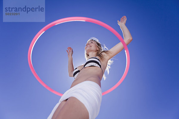 Niederwinkelansicht der Frau Hula Hooping