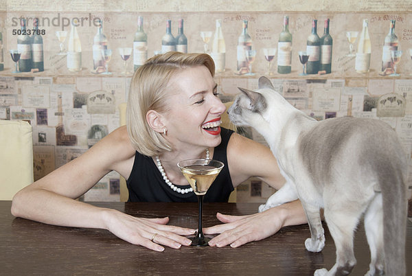 Frau trinkt Martini mit Katze