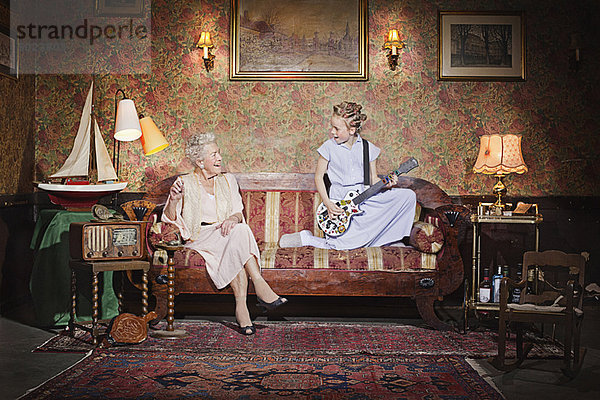 Mädchen spielt Gitarre für Großmutter