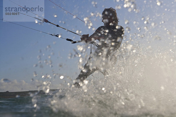 Kitesurfer spritzen im Wasser