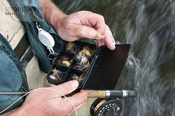 Fliegenfischer mit Fliegenbox im Fluss