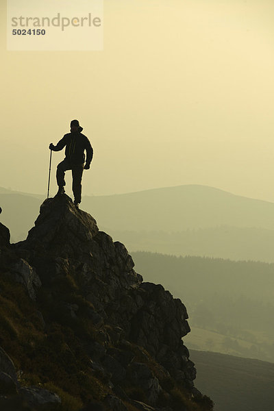 Mann beim Wandern auf felsigen Hängen