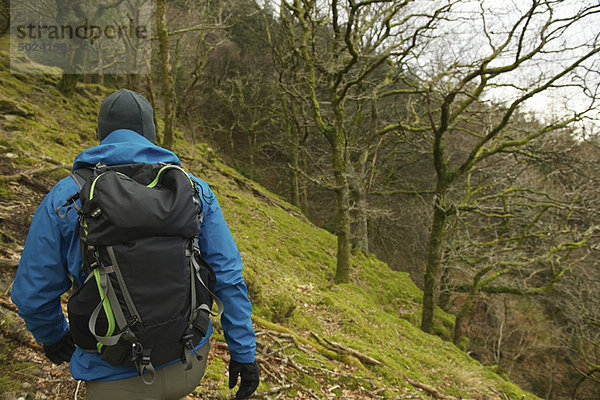 Mann beim Wandern am Hang