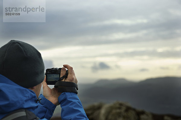 Wanderer beim Fotografieren des Bergblicks