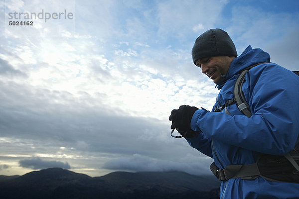 Wanderer mit Digitalkamera am Hang