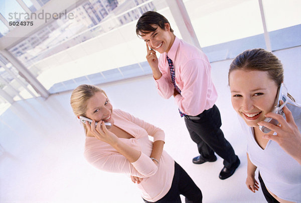 Geschäftsleute  die über Mobiltelefone sprechen