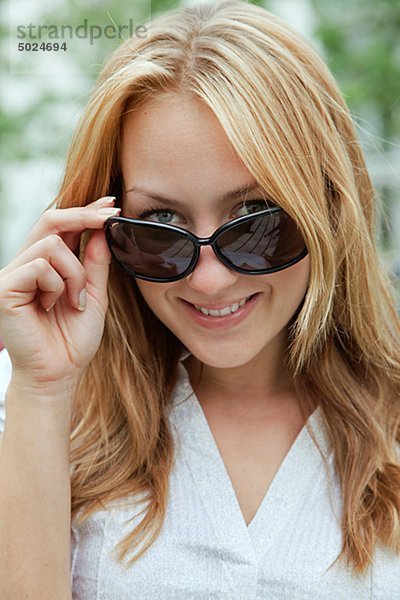 Portrait einer lächelnden Frau mit Sonnenbrille