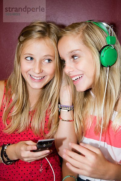 Doppelmädchen hören von Musik von mp3-player