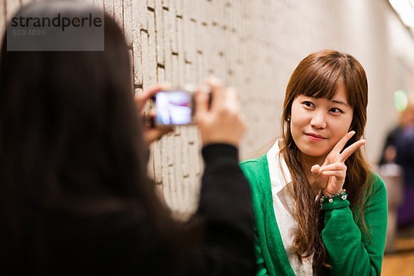 Zwei junge Frauen  die Foto auf Metro-station