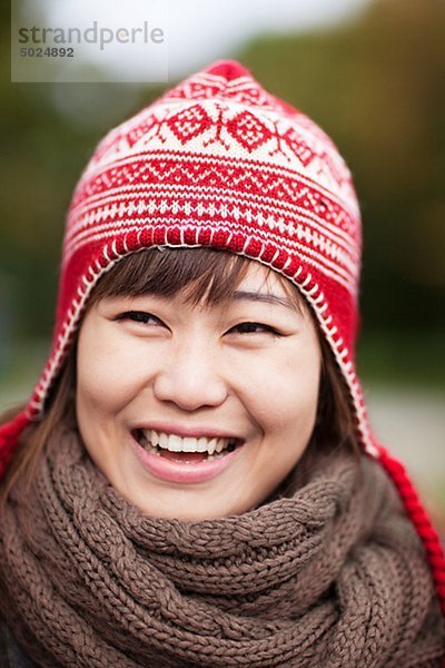Portrait of happy young Woman wooly Hut trägt