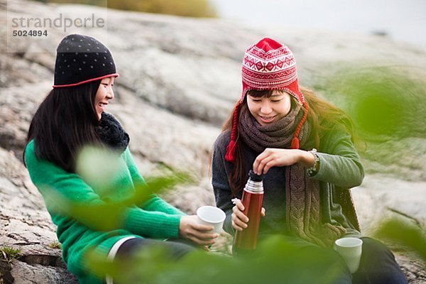 Zwei junge Frauen trinken Kaffee auf Reise