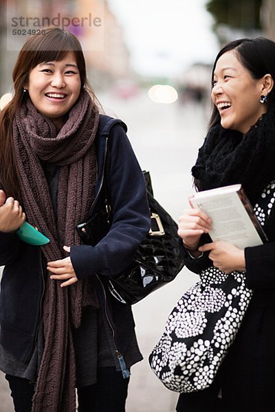 Zwei junge Frauen lachend auf Straße