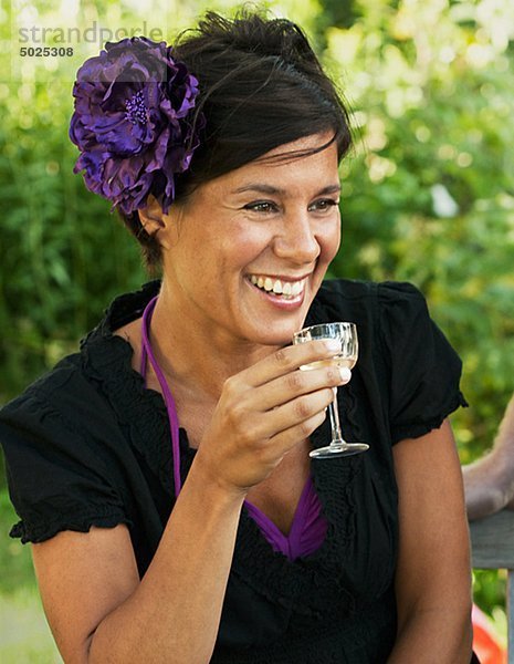 Frau hält Glas Wein  lächelnd  Nahaufname