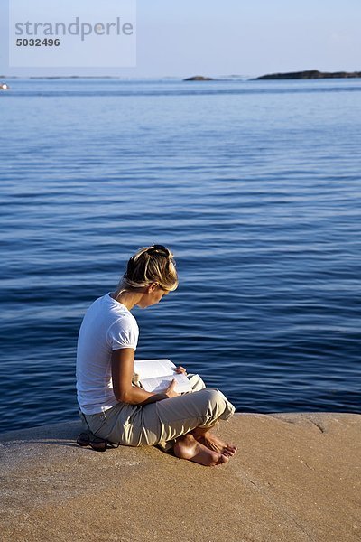 Junge Frau Buch am Meer