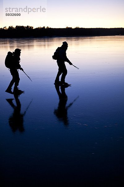 Zwei Personen Eislaufen am zugefrorenen See