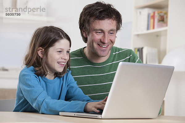 Deutschland  Bayern  München  Vater und Sohn am Laptop  lächelnd