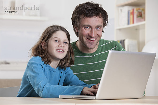 Deutschland  Bayern  München  Vater und Sohn mit Laptop  lächelnd  Portrait