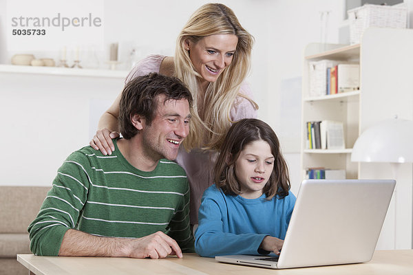 Deutschland  Bayern  München  Familie mit Laptop  lächelnd