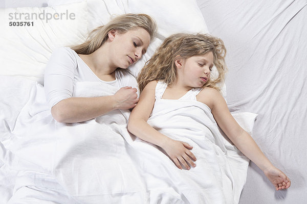Deutschland  Bayern  München  Mutter und Tochter schlafen auf dem Bett