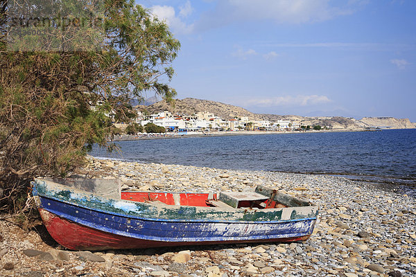 Griechenland  Kreta  Myrtos  Altes Boot am Strand mit Dorf im Hintergrund