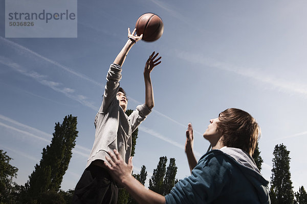 Teenager Jungen Basketball auf dem Spielplatz