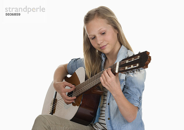 Mädchen spielt Gitarre vor weißem Hintergrund