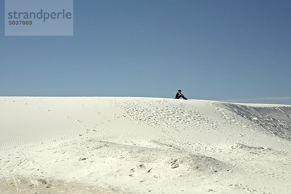 Frau sitzt auf Sand Düne in White Sands National Monument  New Mexico  USA
