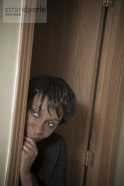 Schwarze Frau einsehen um Ecke von doorway