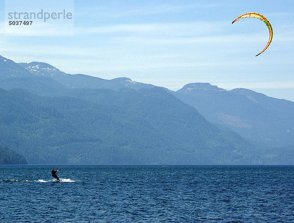 Mann im Anzug Kitesurfing in Ferne auf Harrison Lake in b.c.  Kanada