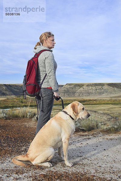 Frau Wandern mit ihrer männlichen yellow Labrador-Apportierhund in den Badlands  Drumheller  Alberta  Kanada