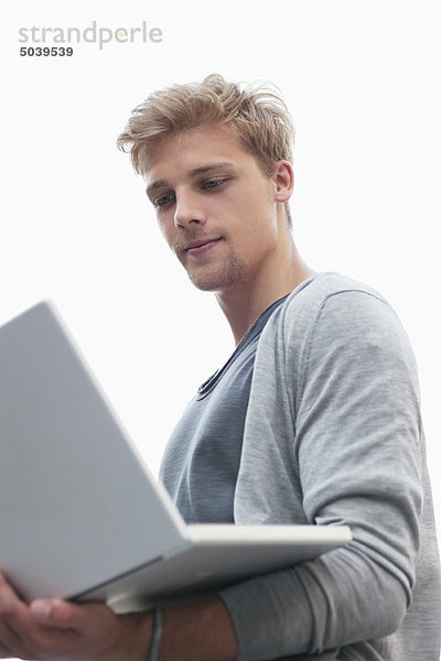 Junger Mann mit einem Laptop